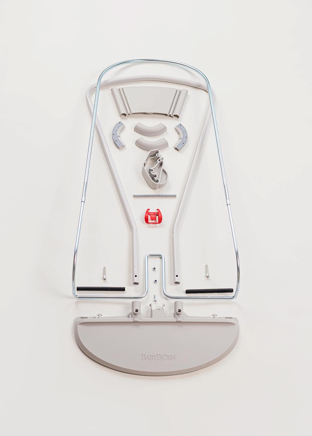 Metal frame and components of a disassembled baby bouncer laid out on a white background.