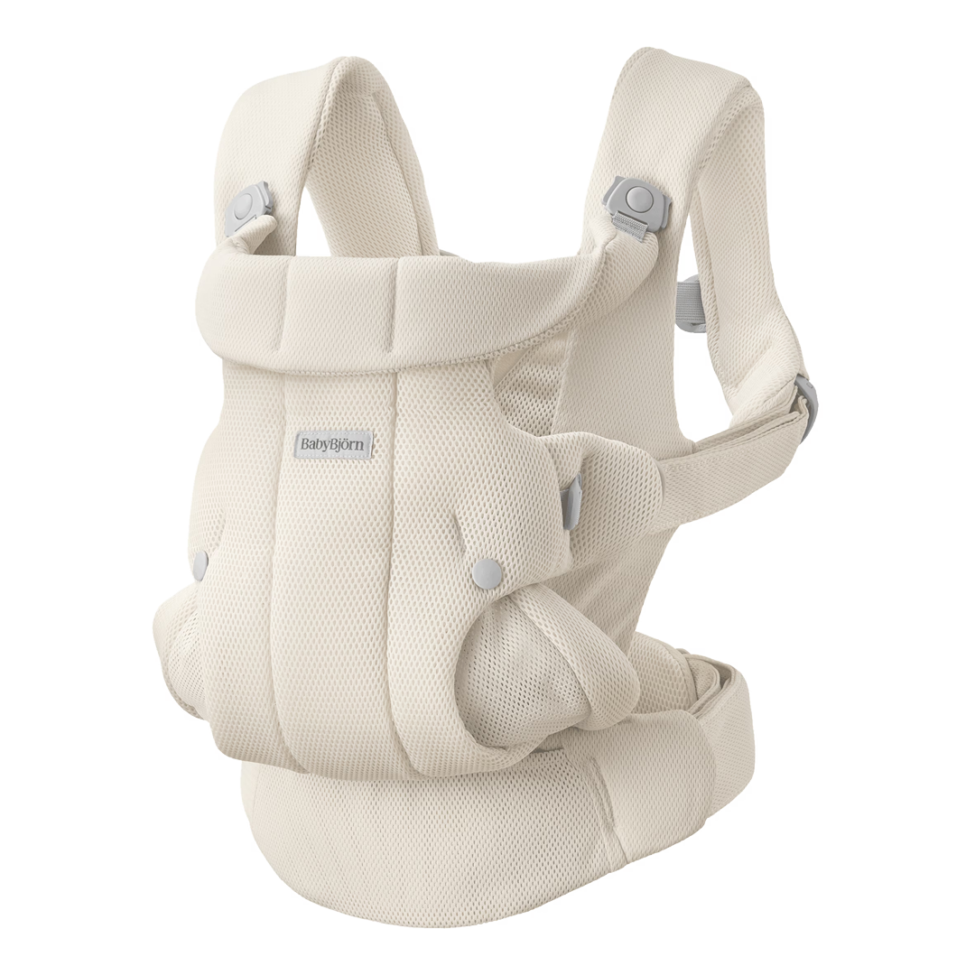 Cream-colored baby carrier with padded shoulder straps and ergonomic design.